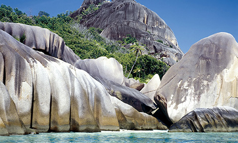 Rocks over the blue seas on a Seychelles yacht charter with Fraser